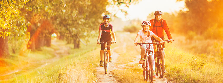 hip replacement surgeon near oswego ny image of elderly couple biking with young girl