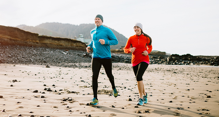 foot doctor near oswego ny image of man and woman jogging on a beach