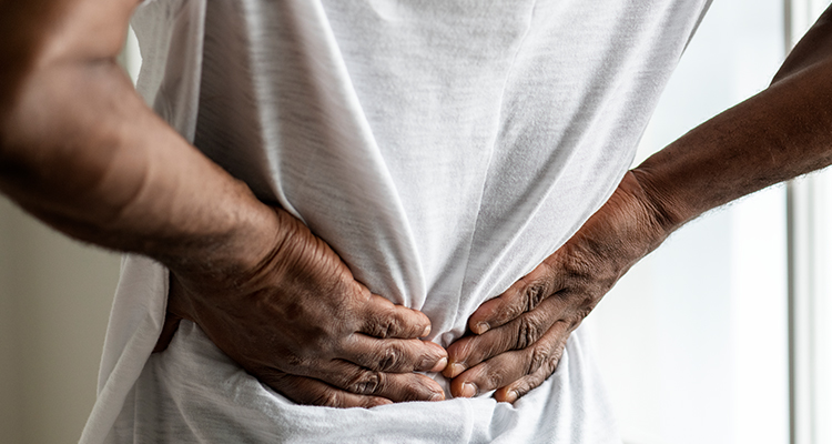 spine doctor near watertown ny image of patient holding lower back in pain