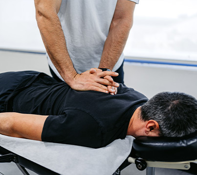 chiropractic care from sos syracuse orthopedic specialists Chiropractor Adjusting His Male Client's Upper Back