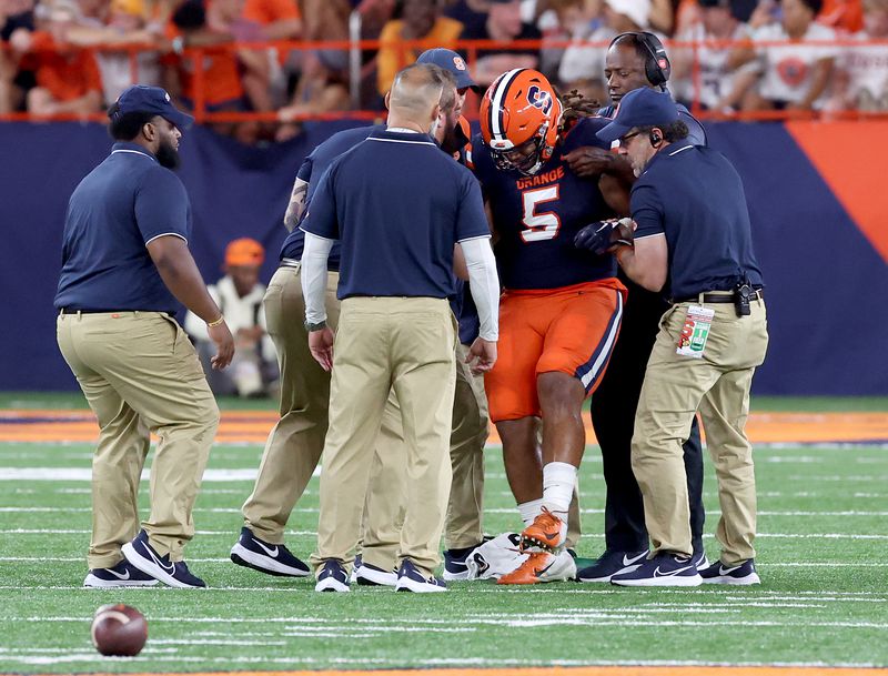 Dr. Todd Battaglia Helps Injured SU Football Player Chris Elmore off Field at the Dome